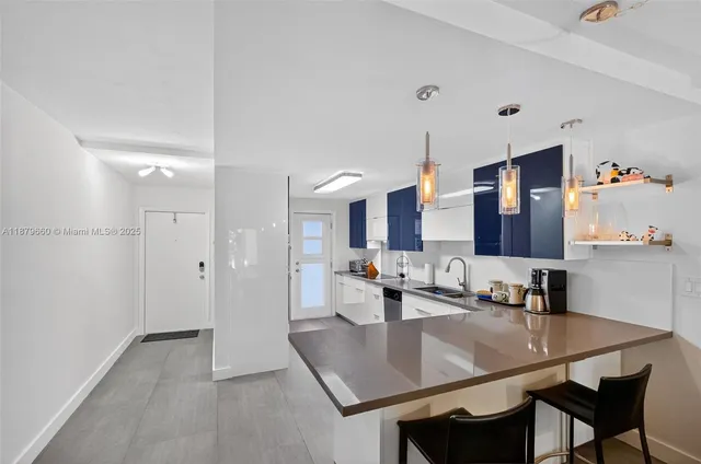 a dining hall with stainless steel appliances kitchen island a table and chairs in it
