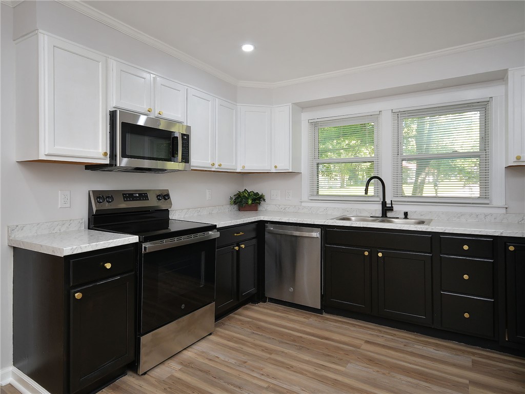 3517 Shawnee Avenue Anderson, SC 29626 - Photo 19 of 25 A well-appointed kitchen features dark lower cabinetry, white upper cabinets, and modern stainless-steel appliances.