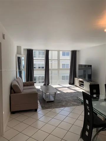 a living room with furniture a large window and a flat screen tv