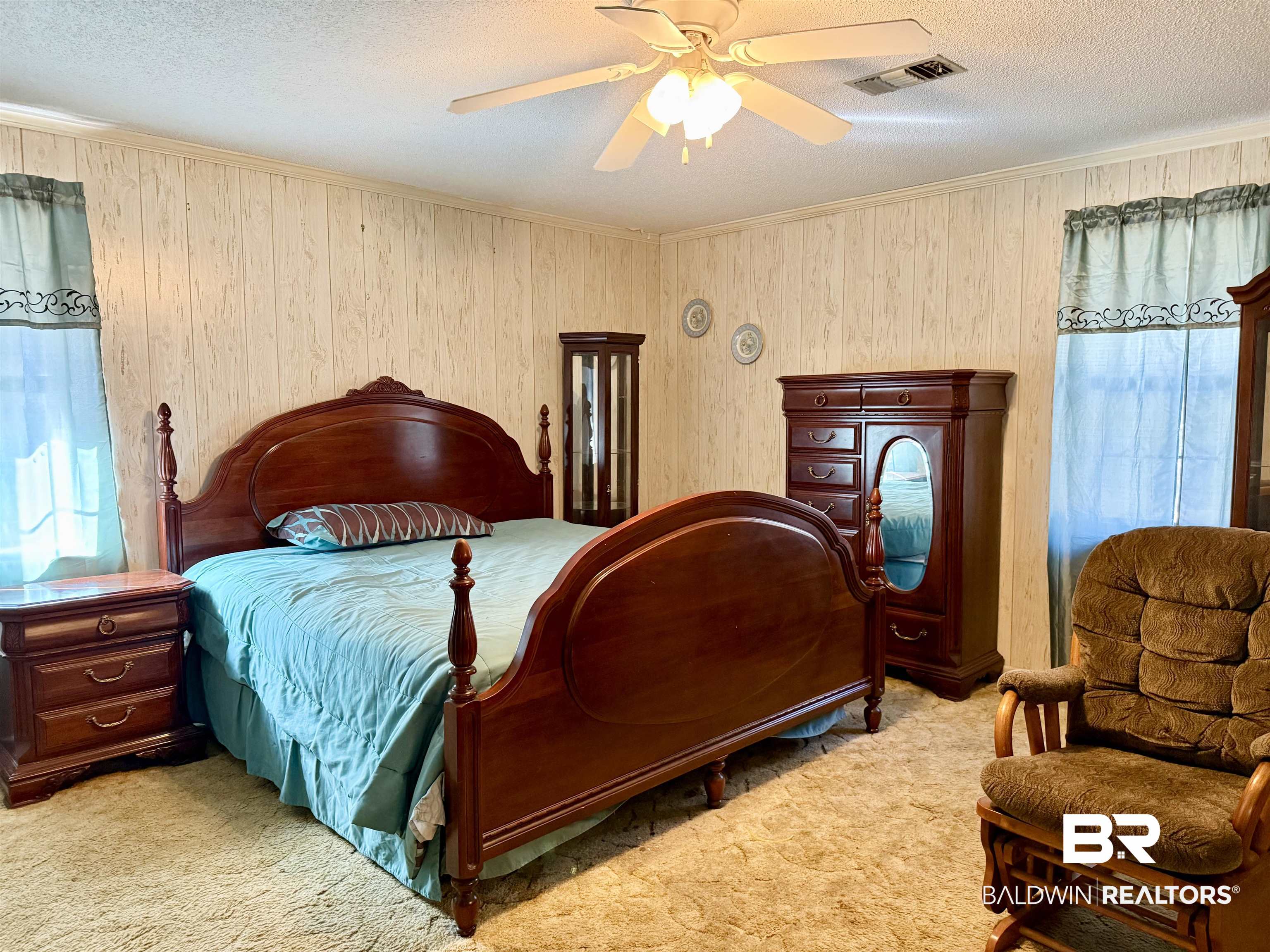 98 Evans Avenue Brewton, AL 36426 - Photo 8 of 18 Bedroom featuring light colored carpet, a textured ceiling, ceiling fan, wood walls, and crown molding