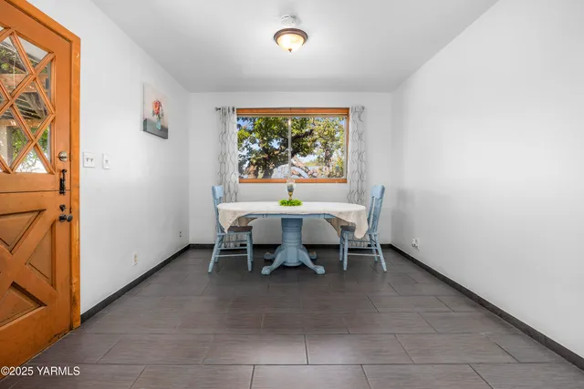 a dining room with furniture and a floor to ceiling window