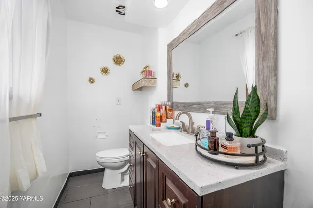 a bathroom with a sink a toilet and a mirror