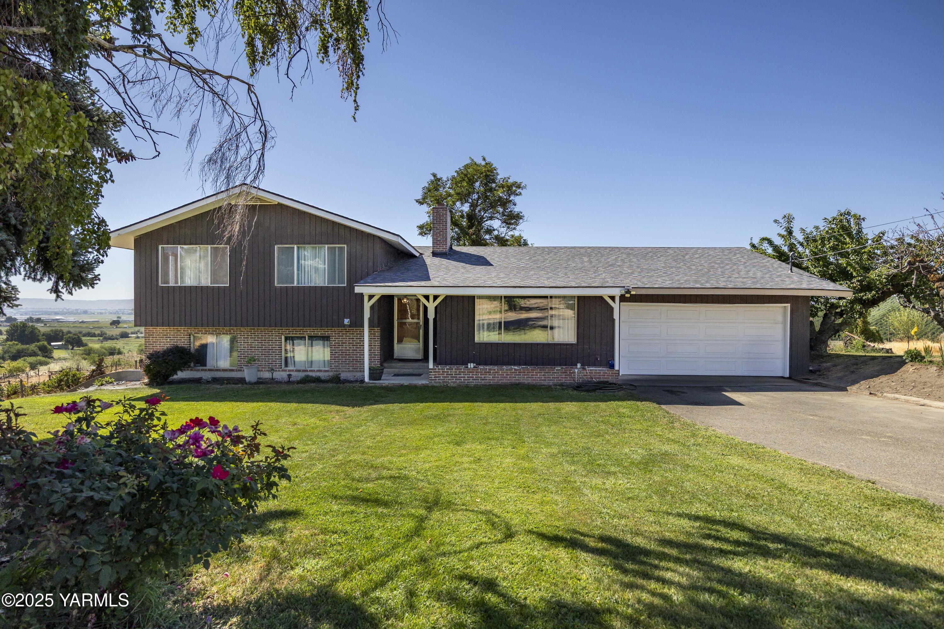 1381 West Riverside Avenue Sunnyside, WA 98944 - Photo 2 of 53 a front view of a house with a garden