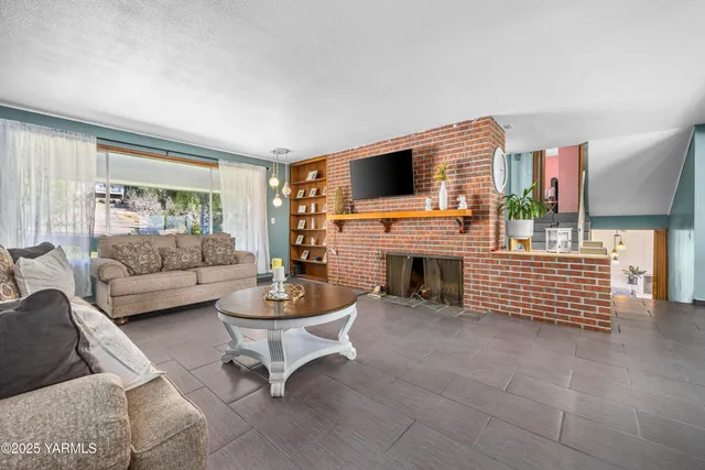 a living room with furniture a fireplace and a flat screen tv
