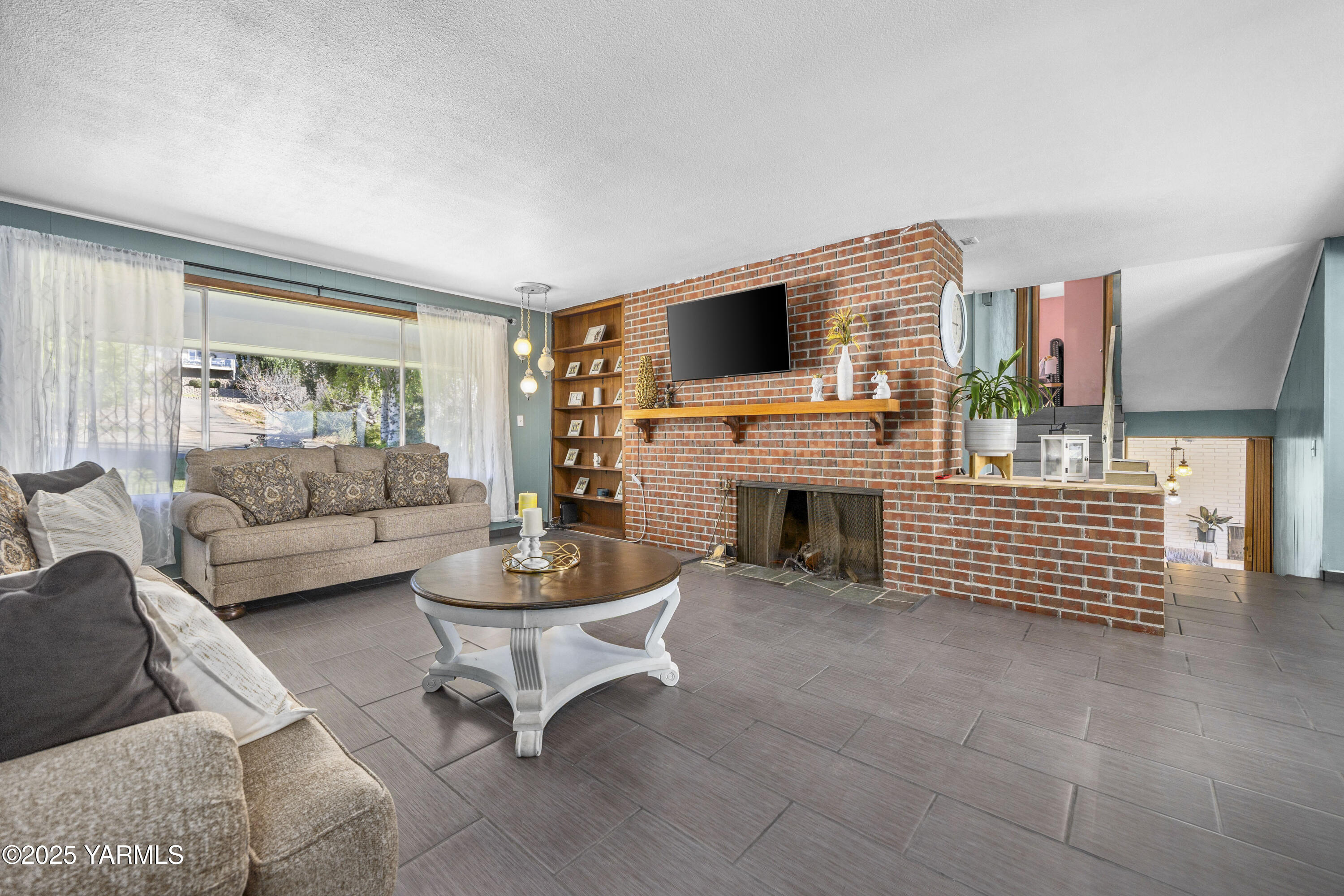 1381 West Riverside Avenue Sunnyside, WA 98944 - Photo 6 of 53 a living room with furniture a fireplace and a flat screen tv
