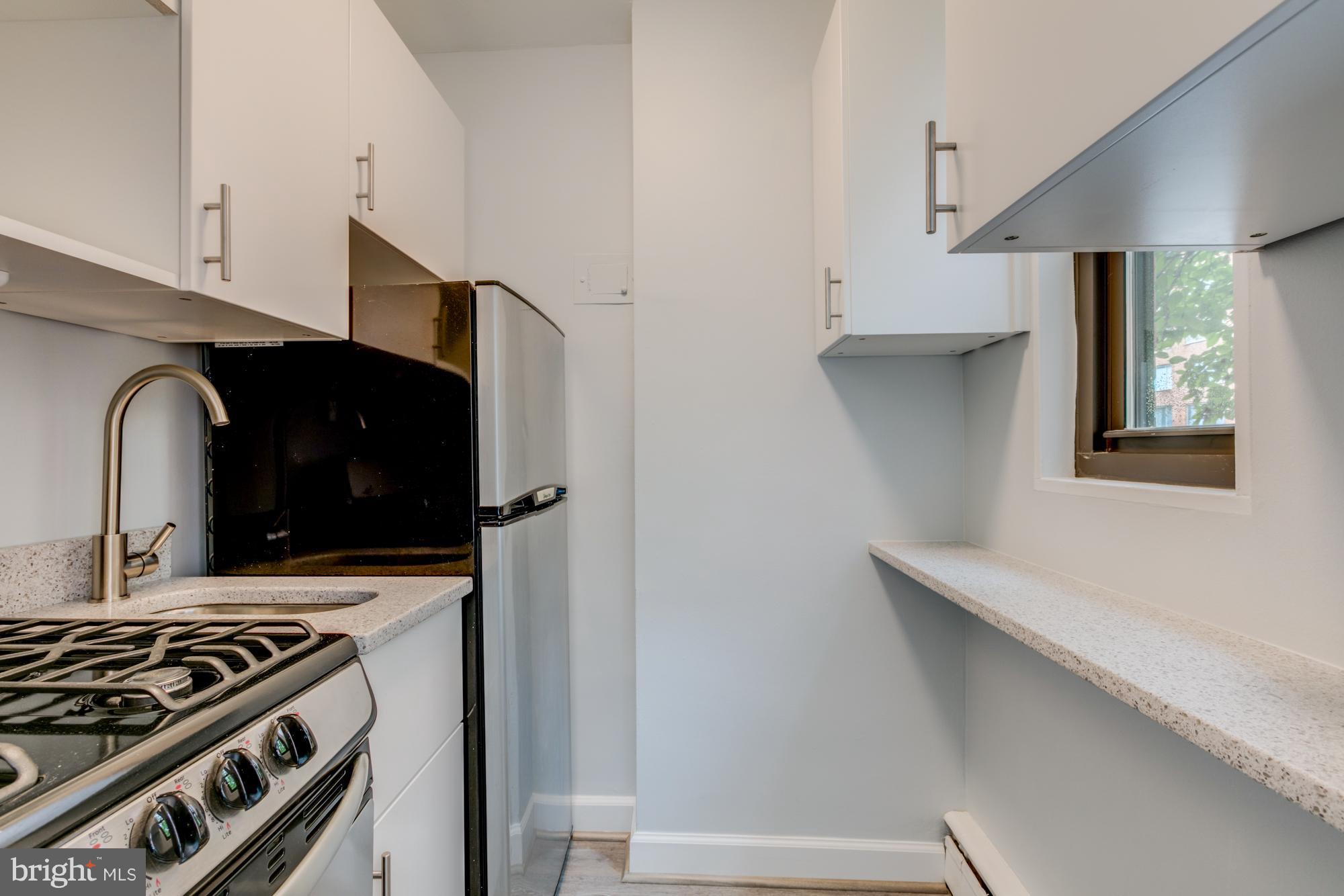 1021 Arlington Boulevard, Unit 647 Arlington, VA 22209 - Photo 11 of 17 a kitchen with a stove and a microwave