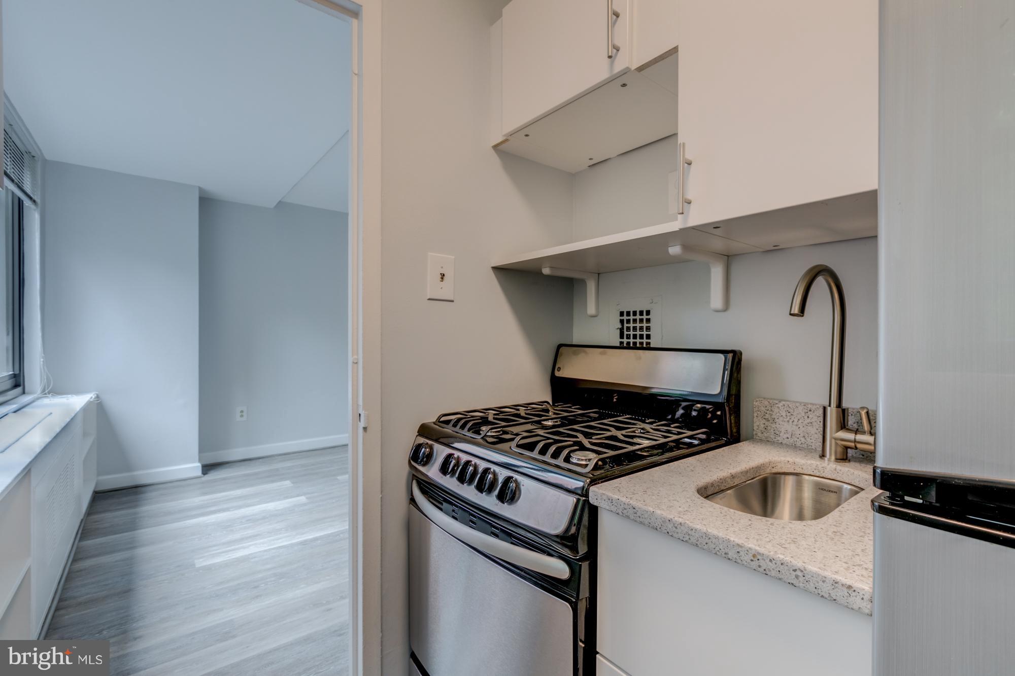 1021 Arlington Boulevard, Unit 647 Arlington, VA 22209 - Photo 13 of 17 a kitchen that has a stove and a wooden floor