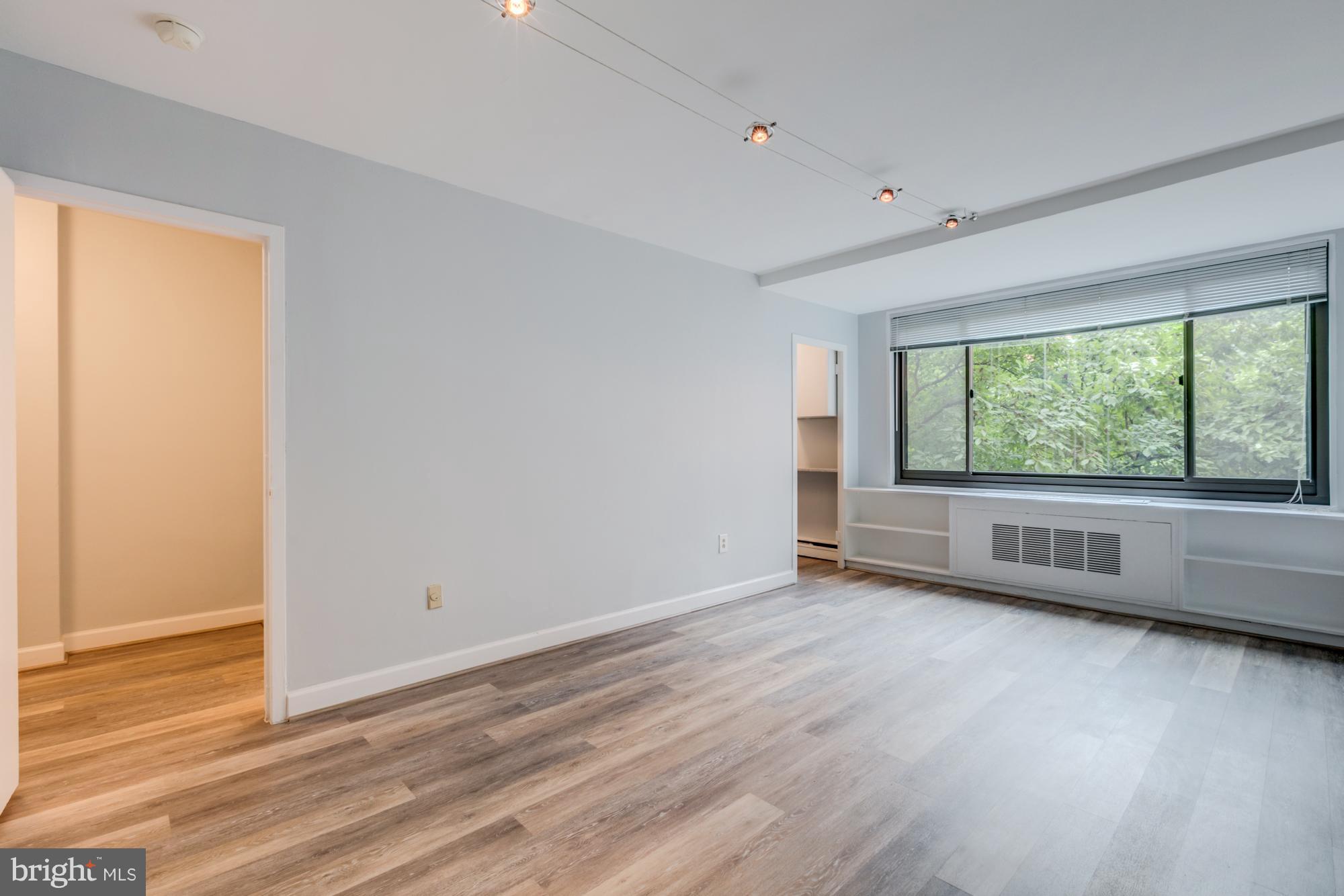 1021 Arlington Boulevard, Unit 647 Arlington, VA 22209 - Photo 16 of 17 an empty room with wooden floor and windows