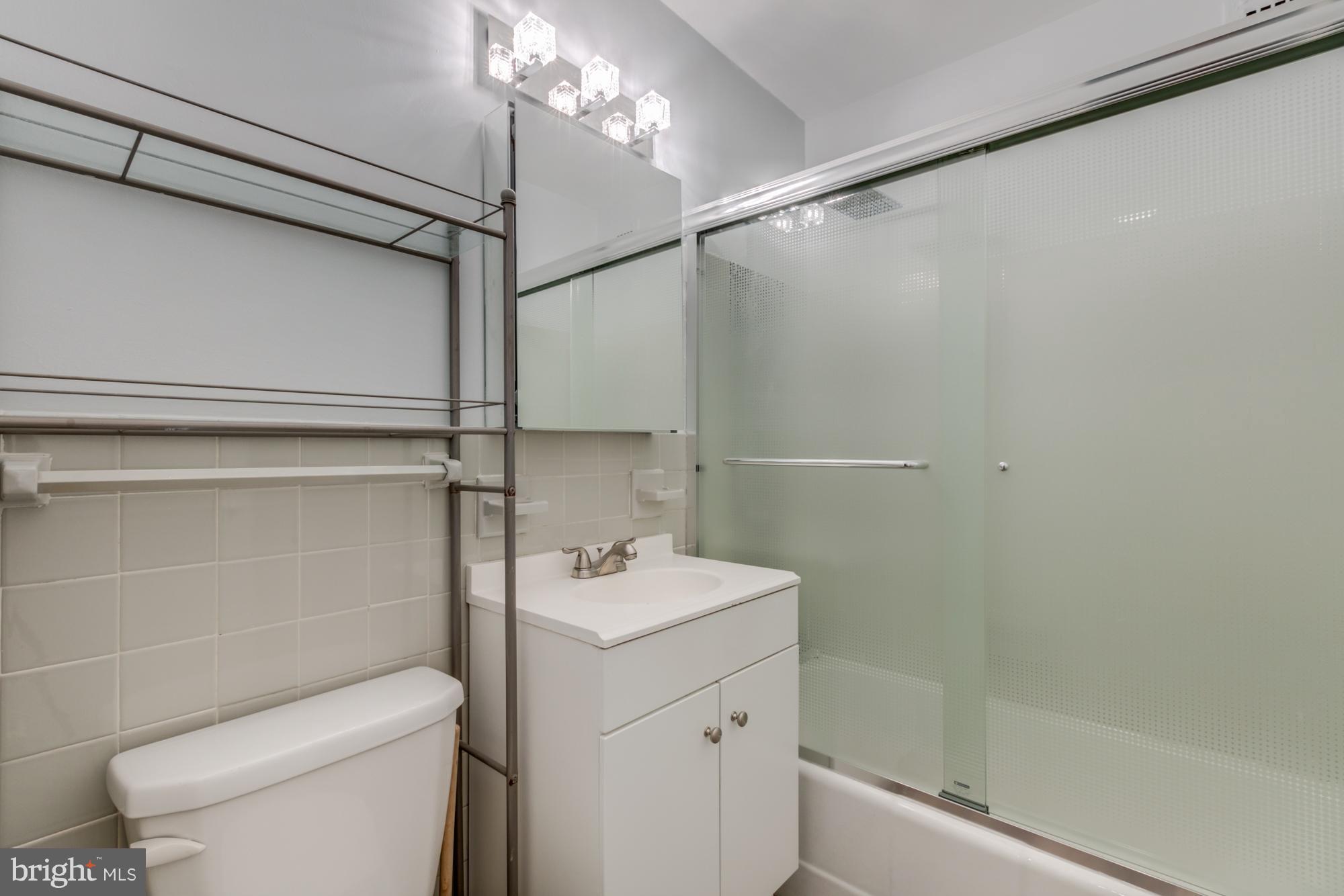1021 Arlington Boulevard, Unit 647 Arlington, VA 22209 - Photo 8 of 17 a bathroom with a sink a toilet and shower