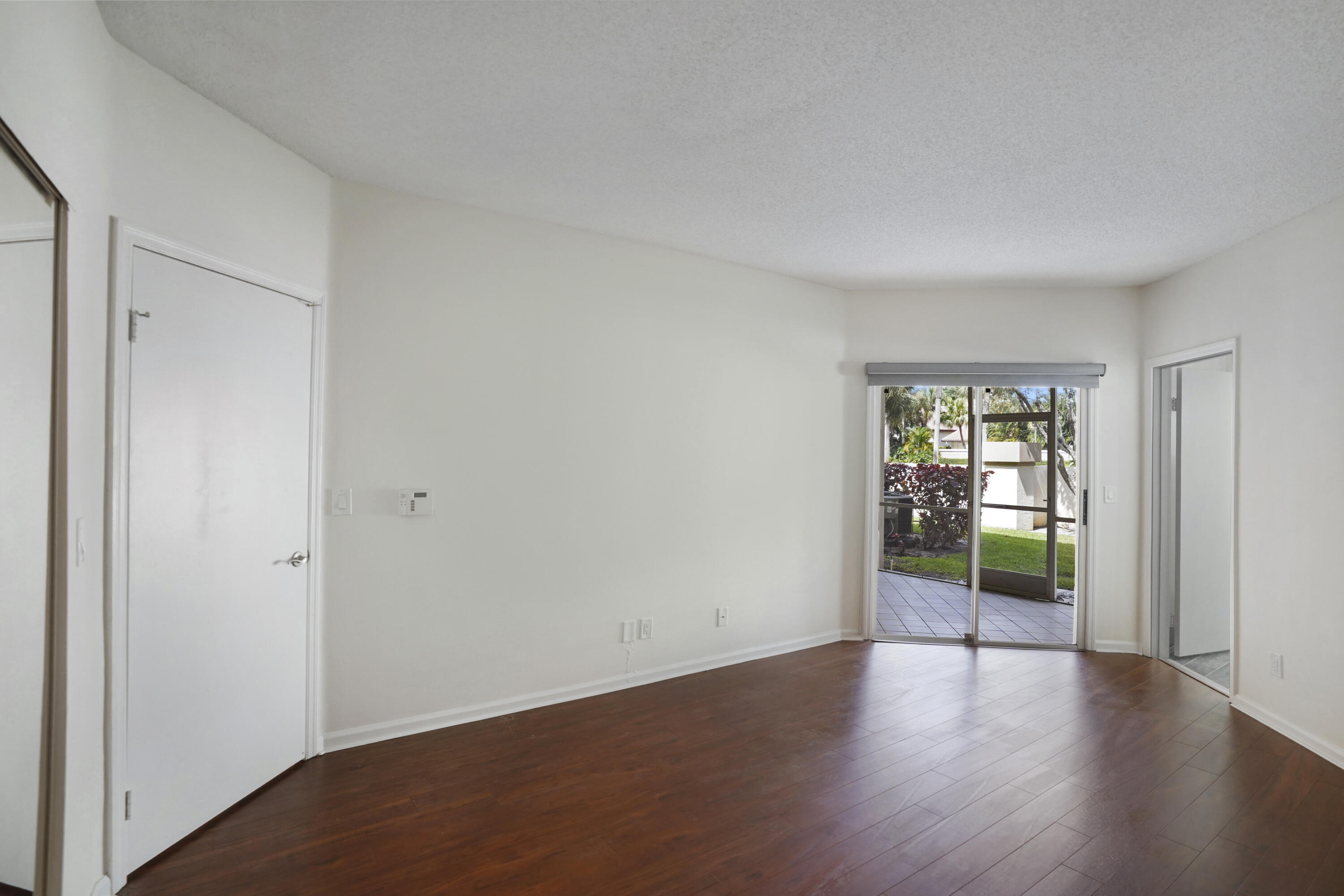 6513 Via Regina Boca Raton, FL 33433 - Photo 16 of 30 an empty room with wooden floor and windows