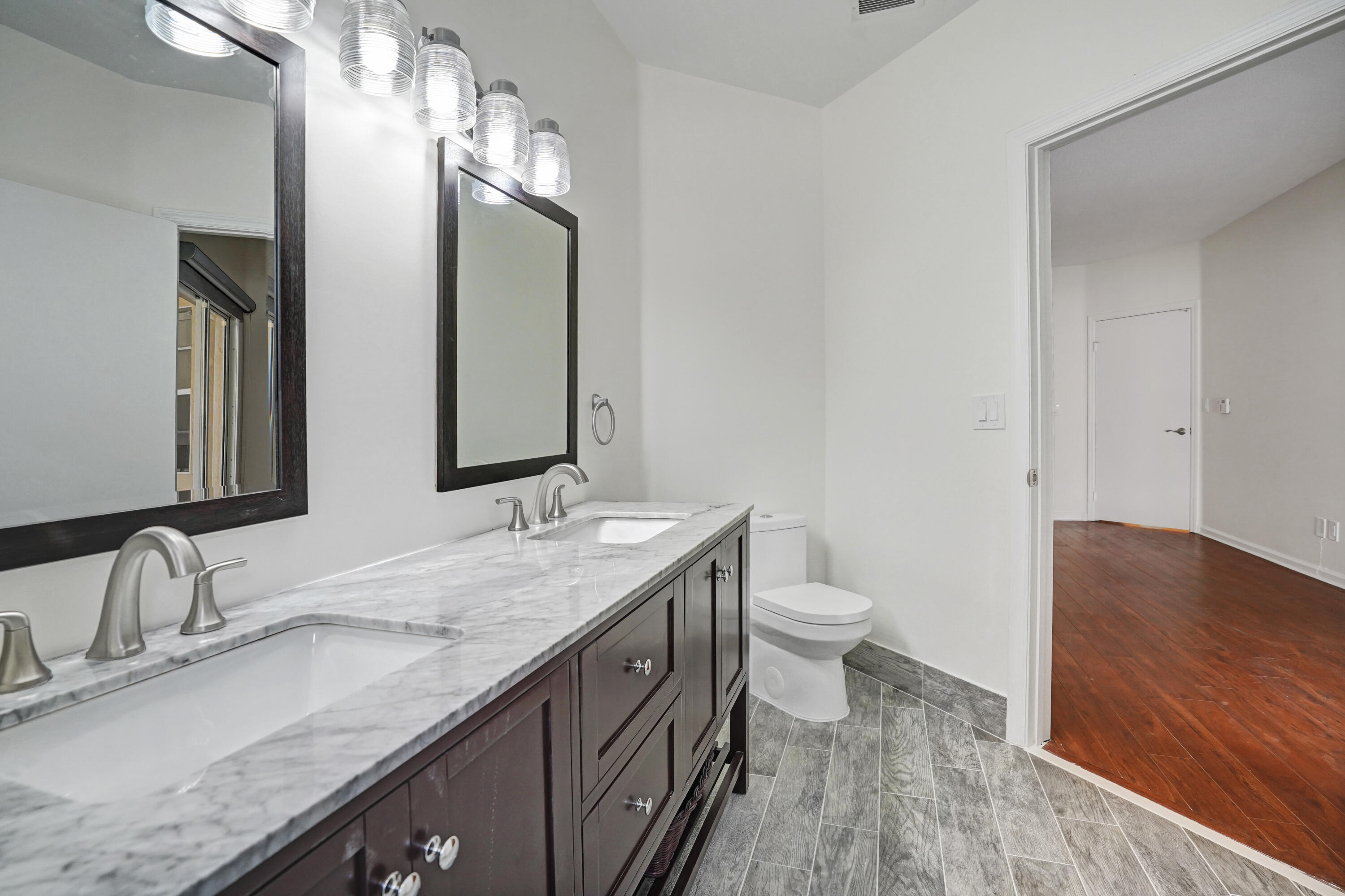6513 Via Regina Boca Raton, FL 33433 - Photo 24 of 30 a bathroom with a granite countertop double vanity sink and a mirror