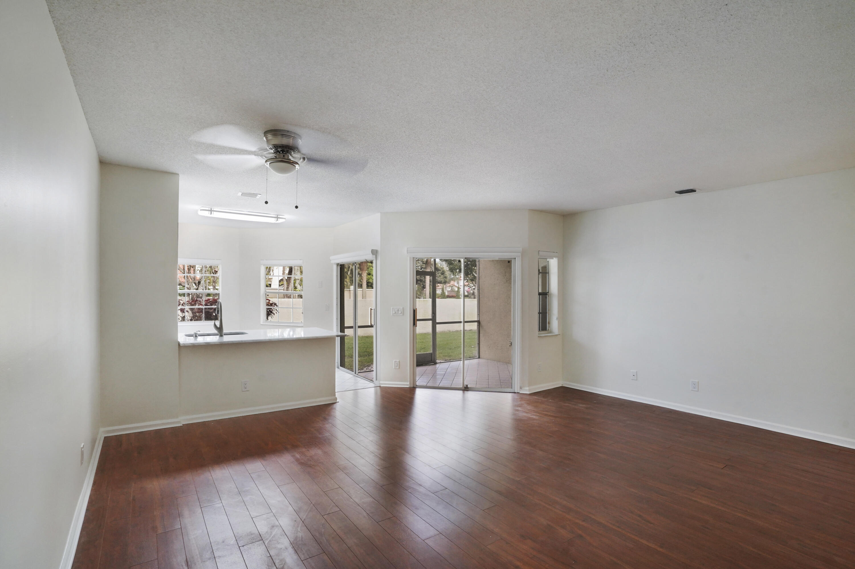6513 Via Regina Boca Raton, FL 33433 - Photo 6 of 30 a view of an empty room with window and wooden floor