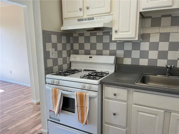 a stove top oven sitting inside of a kitchen