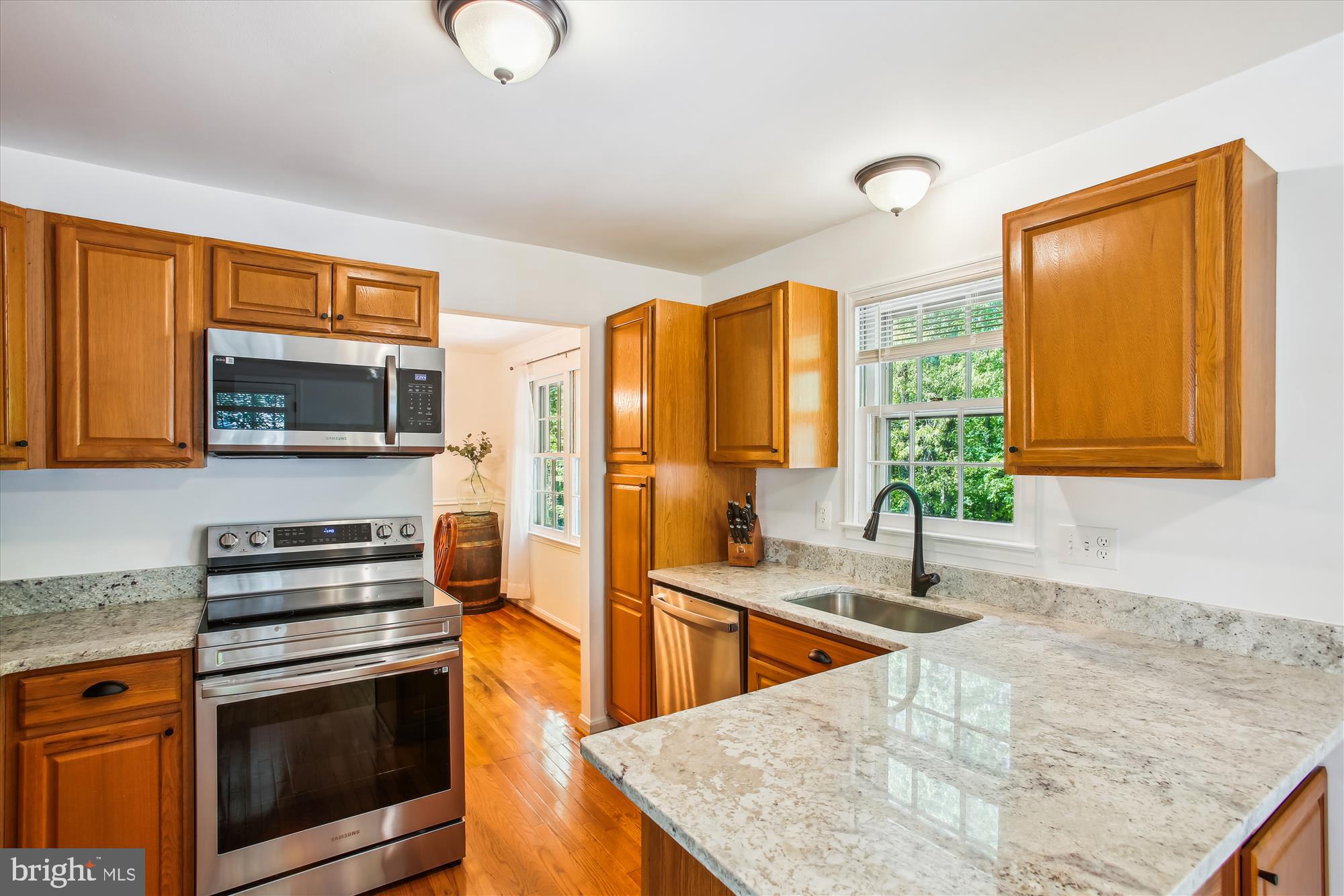 6961 Conservation Drive Springfield, VA 22153 - Photo 19 of 62 a kitchen with stainless steel appliances granite countertop a sink a stove and a microwave