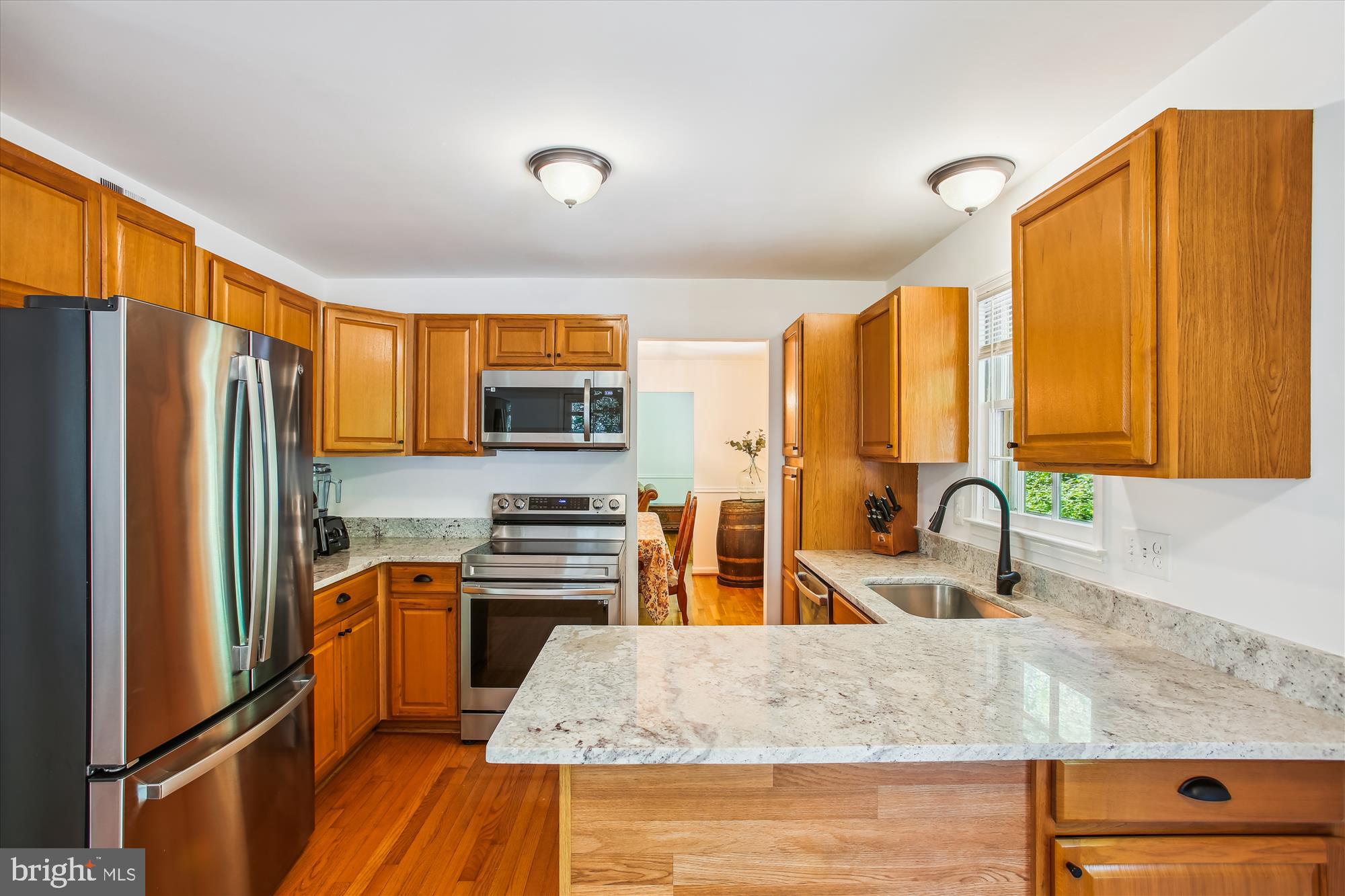 6961 Conservation Drive Springfield, VA 22153 - Photo 28 of 62 a kitchen with stainless steel appliances granite countertop a refrigerator a stove and a sink with wooden floor