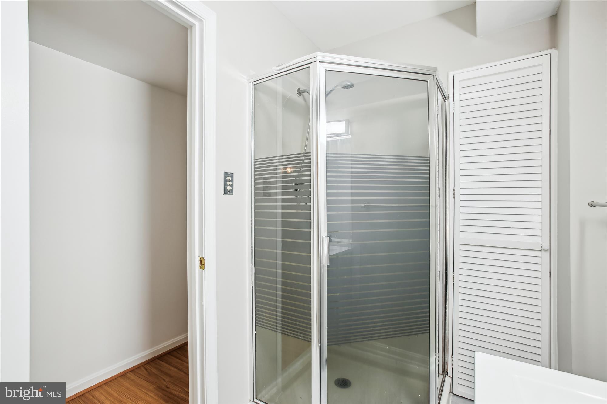 6961 Conservation Drive Springfield, VA 22153 - Photo 34 of 62 a bathroom with a glass shower door