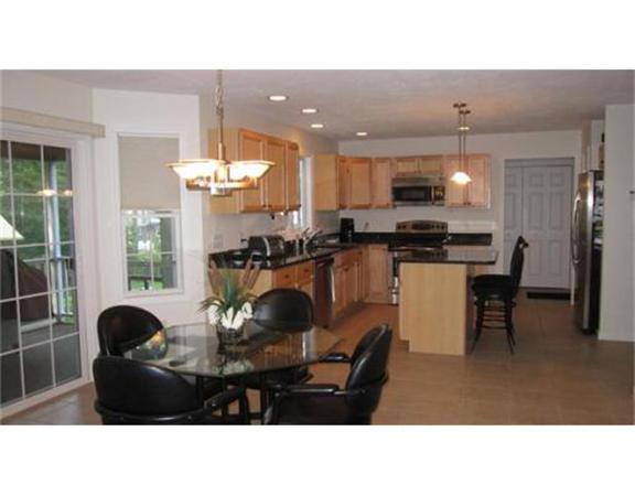 45 Tannery Road Sturbridge, MA 01518 - Photo 12 of 30 a kitchen with a table chairs a refrigerator and cabinets