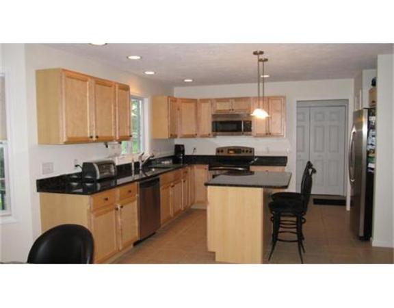 45 Tannery Road Sturbridge, MA 01518 - Photo 13 of 30 a kitchen with kitchen island granite countertop a sink a counter top space appliances and cabinets