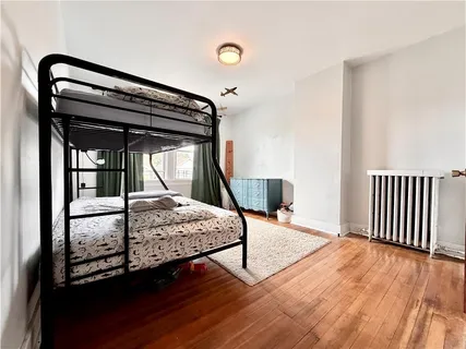 a bedroom with a bed window and wooden floor