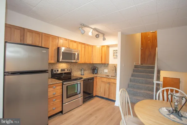 a kitchen with stainless steel appliances granite countertop a refrigerator a stove a sink and a refrigerator
