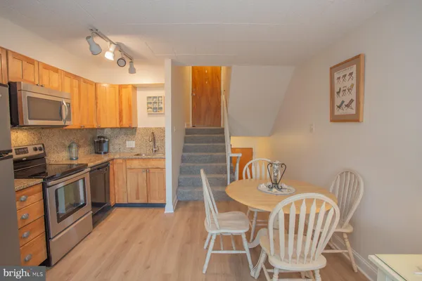 a kitchen with stainless steel appliances a dining table and chairs