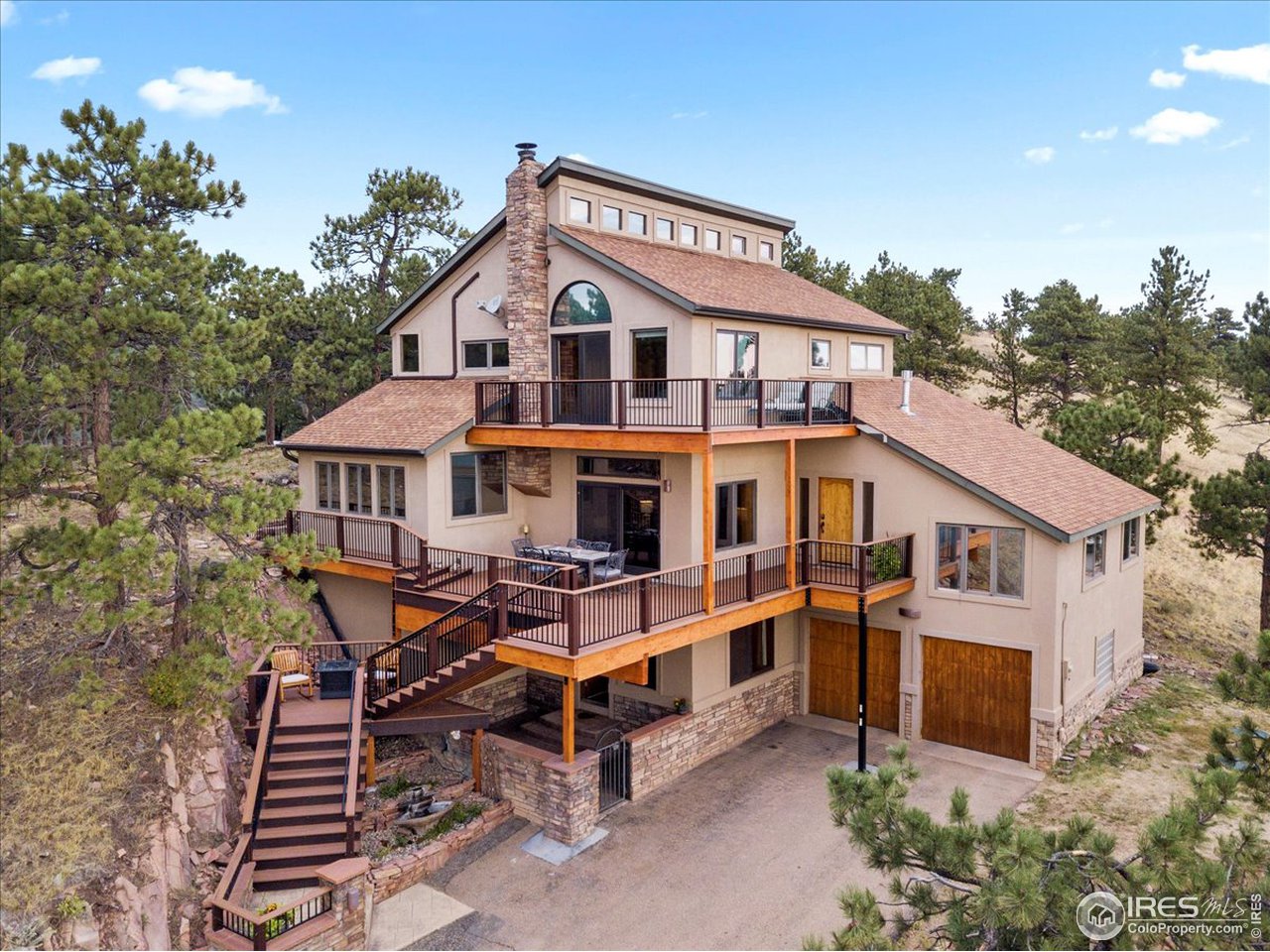 an aerial view of a house with yard and trees in the background