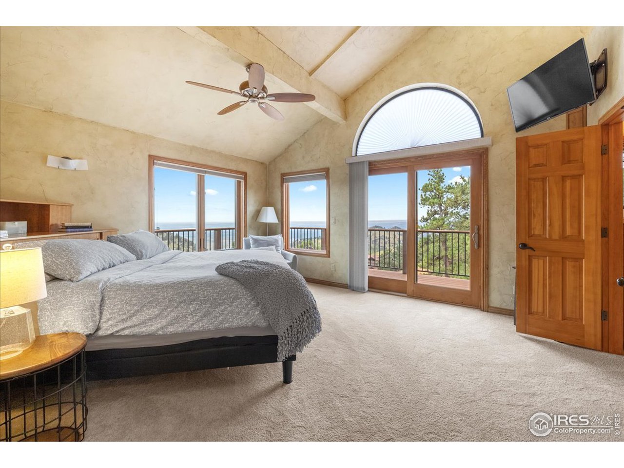 6293 Red Hill Road Boulder, CO 80302 - Photo 18 of 40 a spacious bedroom with a bed a table and large windows