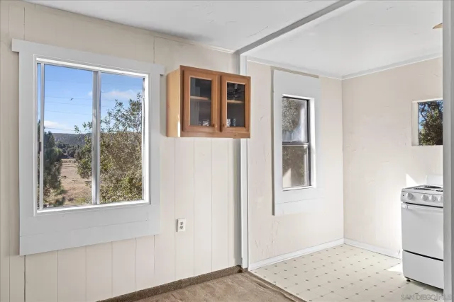 a view of an empty room with window and refrigerator