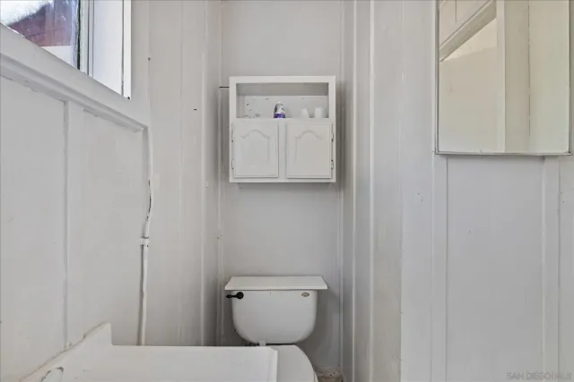 a bathroom with a toilet and a mirror
