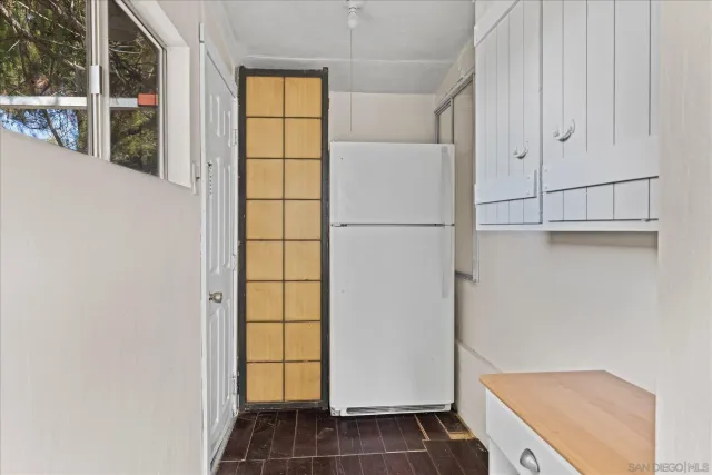 a view of a kitchen with white cabinets and wooden floor