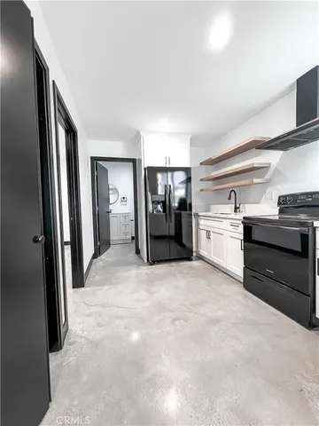 a large white kitchen with stainless steel appliances granite countertop a refrigerator and a stove top oven