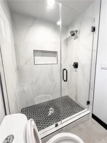 a bathroom with a sink a toilet a shower and mirror