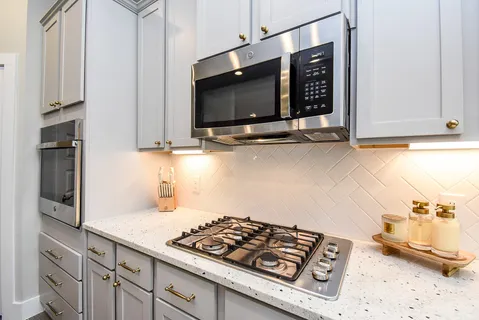 a kitchen with stainless steel appliances granite countertop a stove and a microwave