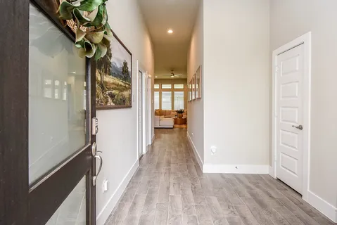 a view of a hallway with wooden floor and staircase