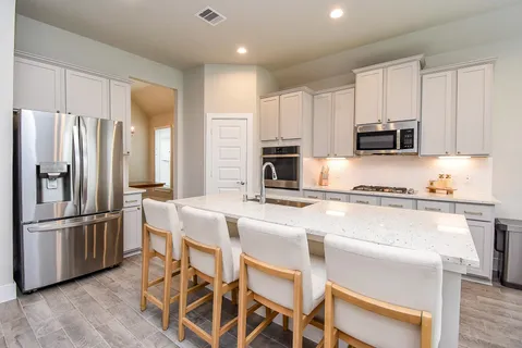 a kitchen with stainless steel appliances granite countertop a refrigerator and a stove top oven