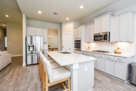 a kitchen with stainless steel appliances a stove a sink a refrigerator and cabinets
