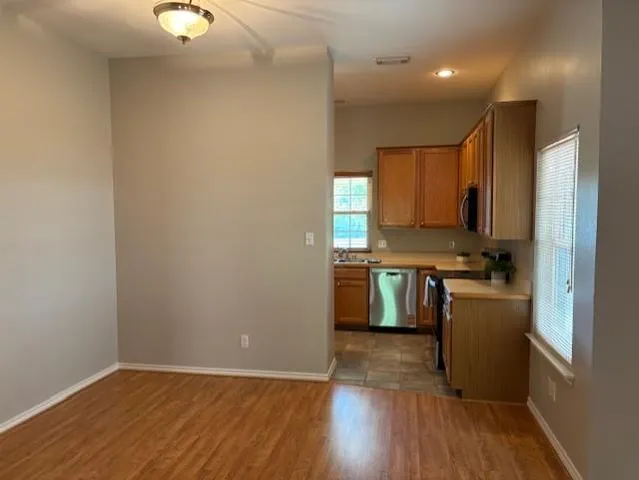 a kitchen with a refrigerator a stove top oven and wooden floor