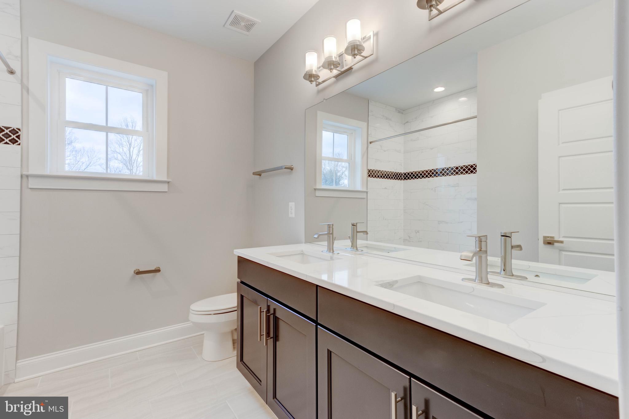 3114 Mt Zion Road Upperco, MD 21155 - Photo 33 of 61 a bathroom with a double vanity sink a toilet and a mirror