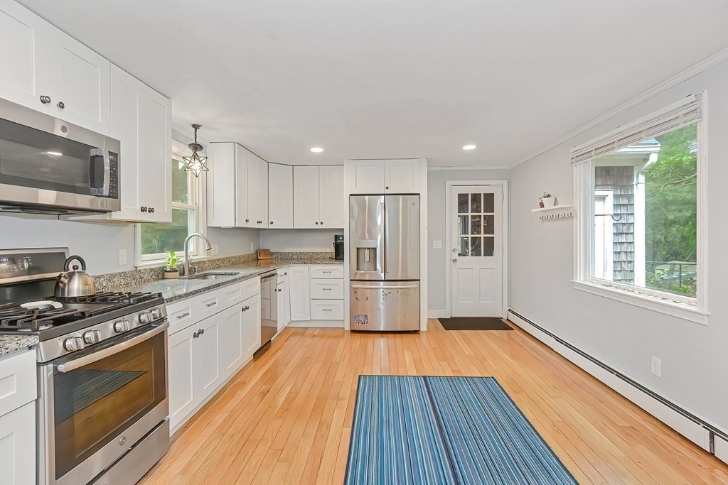 79 Emerson Way Barnstable, MA 02632 - Photo 7 of 29 a kitchen with stainless steel appliances a stove a sink dishwasher a refrigerator and a microwave oven with wooden floor