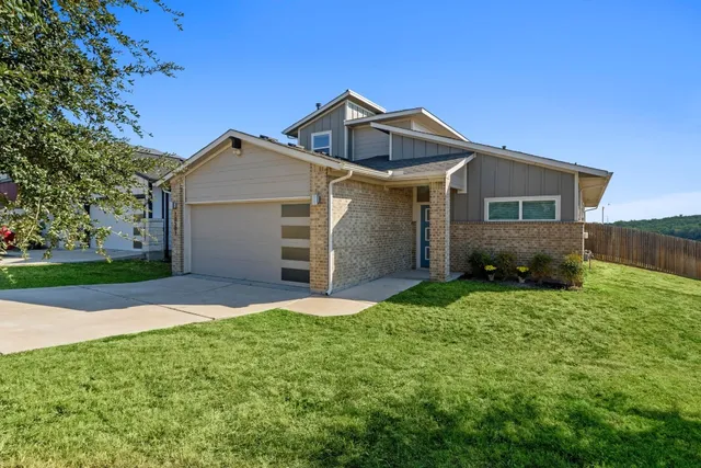 a front view of a house with a yard and garage
