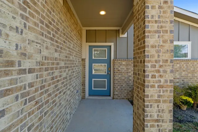 a view of a dining room and livingroom with furniture wooden floor a rug a fireplace and a chandelier