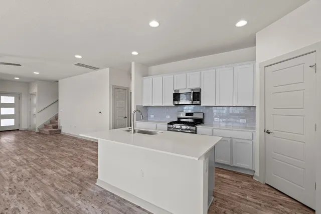 a kitchen with a sink and a stove top oven
