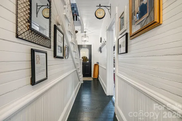 a view of a hallway with wooden floor and staircase