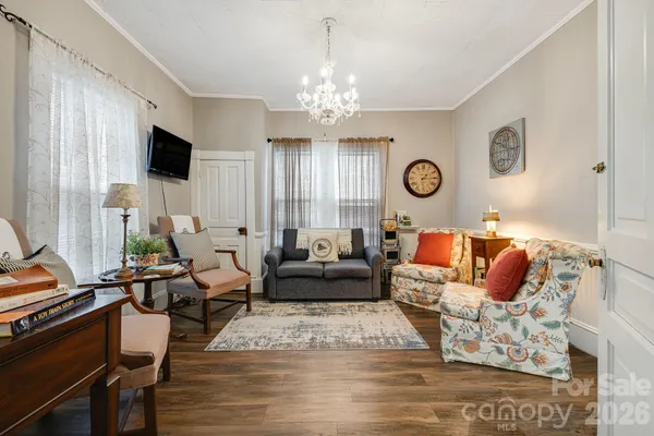 a living room with furniture wooden floor and a chandelier