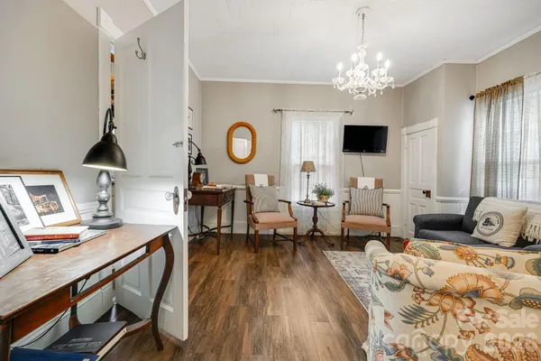a living room with furniture a dining table and a chandelier