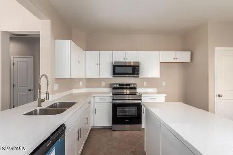 40620 North Key Lane Anthem, AZ 85086 - Photo 11 of 24 a kitchen with white cabinets and white appliances