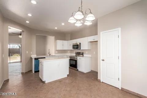 40620 North Key Lane Anthem, AZ 85086 - Photo 15 of 24 a kitchen with kitchen island white cabinets and stainless steel appliances