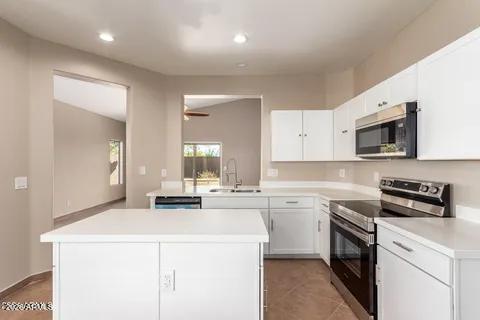 40620 North Key Lane Anthem, AZ 85086 - Photo 3 of 24 a kitchen with a sink a stove and cabinets