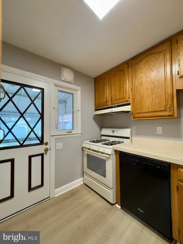 a kitchen with cabinets wooden floor and stainless steel appliances