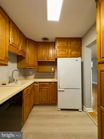 a kitchen with a sink refrigerator and cabinets